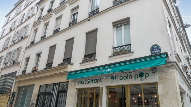 A building with a restaurant named 'coin pop' on the ground floor.