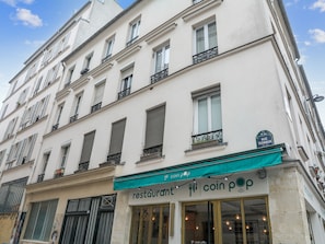 Um edifício com um restaurante chamado 'coin pop' no andar térreo.