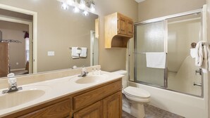 Une salle de bain avec un meuble-lavabo à deux vasques, des toilettes et une douche à l’italienne.