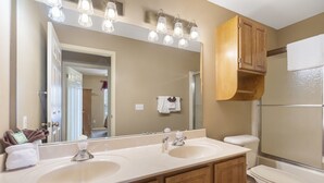 A bathroom with a double sink vanity, a large mirror, and a toilet. - Cozy Suite with Kitchenette at Relaxing StoneBridge Village (Reeds Spring)