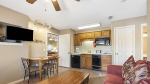 A compact living space with a dining area, kitchenette, and a sofa. - Cozy Suite with Kitchenette at Relaxing StoneBridge Village (Reeds Spring)