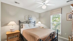 A bedroom with a bed, two bedside tables, a ceiling fan, and a window with blinds. - Cute Queen Suite at StoneBridge  Village - minutes from SDC! (Reeds Spring)