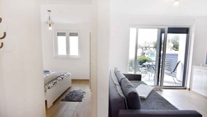 Ein modernes Wohnzimmer mit einer Couch, einem kleinen Tisch und einem Fenster.