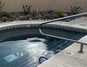 A swimming pool with a metal handrail, surrounded by rocks and plants. - Comfy Studio in SW resort near golf courses and mountain/desert hiking (Green Valley)