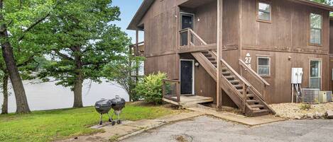A two-story wooden building with a staircase, a door labeled '27', and a view of a lake.