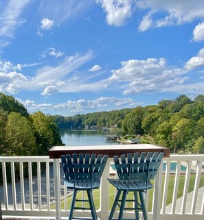 A balcony with two chairs overlooking a lake and forested area. - Waterfront Condo!  (Moneta)