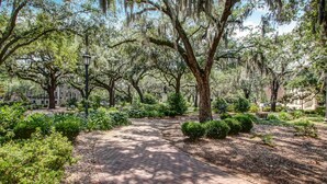 A paved pathway in a park with mature trees and well-maintained greenery. - Great Location Downtown, Heated Pool Access (Savannah)
