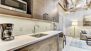 A modern kitchen with a built-in microwave, stainless steel appliances, and a coffee maker. - Great Location Downtown, Heated Pool Access (Savannah)