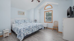 A bedroom with a bed, a ceiling fan, a window, a chair, and a TV. - 1747 - Resting Beach Place, Pool, Hot Tub & Game Room | Sleeps 15 in Corolla (Corolla)