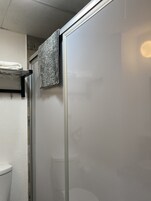 Standaard kamer | Badkamer | Een douche, handdoeken, zeep, shampoo