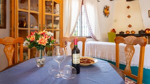A dining table with a wine bottle, glasses, and a plate of food. - Cortijo La Reina by Solset (Torrox)