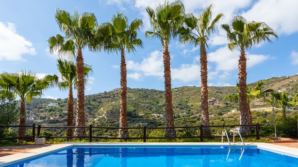 A swimming pool with a view of palm trees and a hilly landscape in the background. - Cortijo La Reina by Solset (Torrox)