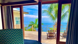 Una habitación con cama, una silla y vista al océano.