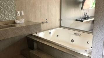 Une salle de bain moderne avec une baignoire sur pieds, un grand miroir et un revêtement mural texturé.