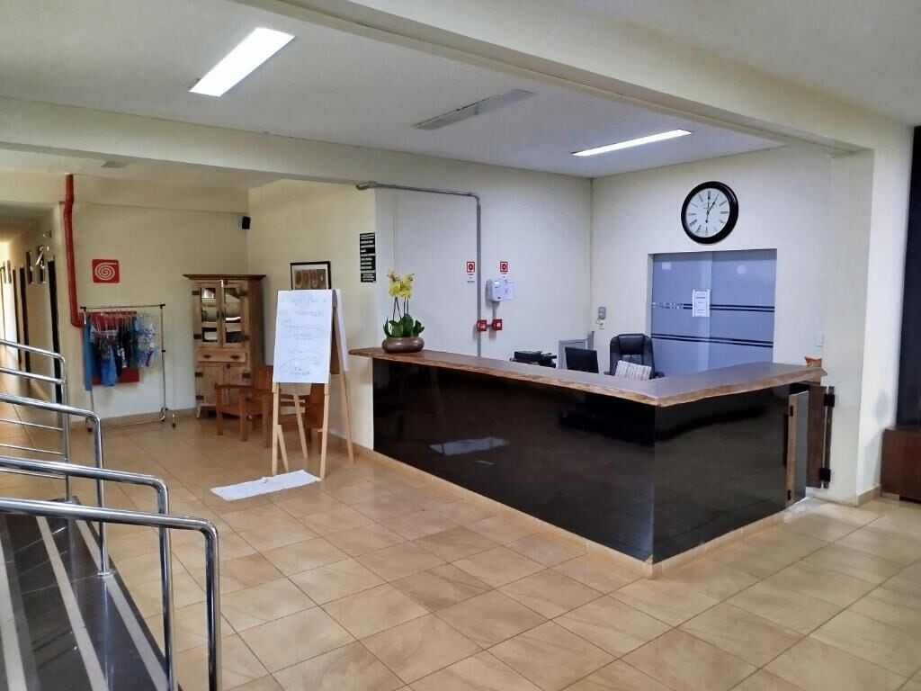 Zona de recepción con mostrador, un reloj y una pizarra.