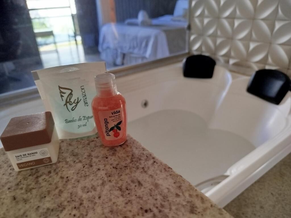 A bathroom with a bathtub, a shower, and a countertop with toiletries.