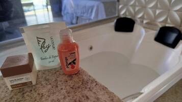 A bathroom with a bathtub, a shower, and a countertop with toiletries.
