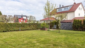 Un quartier résidentiel avec une pelouse bien entretenue, un mur en pierre et des maisons aux toits rouges.