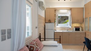 Une cuisine compacte équipée d’un réfrigérateur, d’un four à micro-ondes et d’un évier.