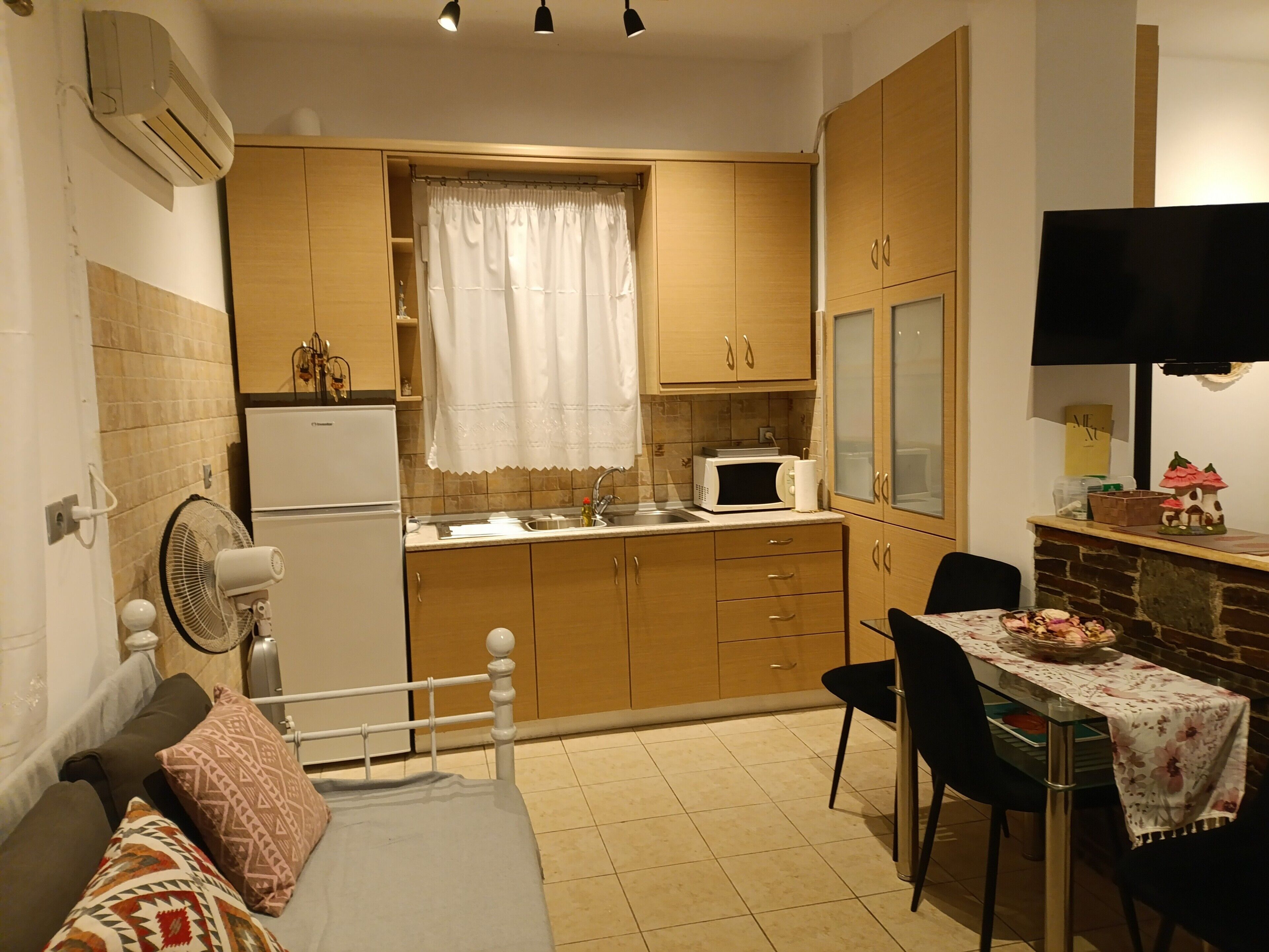 A compact kitchen with a refrigerator, microwave, and dining area with chairs and a table.