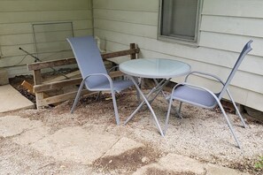 A patio with two metal chairs and a small round table. - Rogers' Rambler (Bloomington)