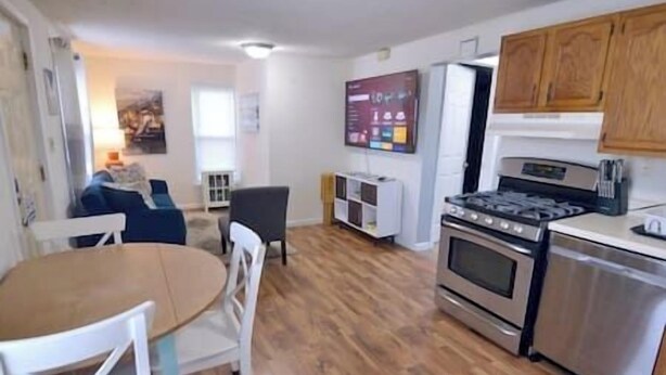 A compact kitchen with a dining area, wooden cabinets, and a built-in oven.