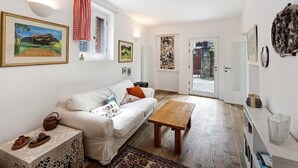 A cozy living room with a white sofa, a wooden coffee table, and a patterned rug. - Holiday Home 'Casa Romantica' with Private Terrace, Balcony and Wi-Fi (Ispra VA)