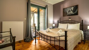 Une chambre à coucher avec un lit, un radiateur, une fenêtre avec des rideaux, un tableau au mur et un plancher en bois.