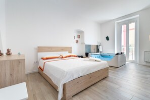Ein modernes Schlafzimmer mit einem hölzernen Bett, einem weißen Nachttisch, einer integrierten Badewanne und einem großen Fenster.