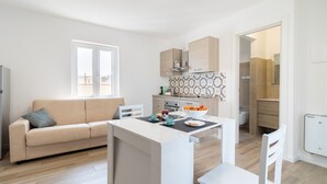 Una cocina moderna con una isla central, un sofá y un comedor.