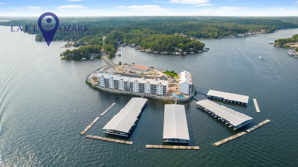 An aerial view of a lakeside resort with multiple buildings, docks, and boats.
