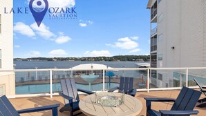 Una terrazza con piscina, sedie a sdraio e ringhiera in vetro che si affaccia su una distesa d'acqua.