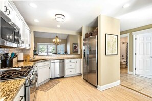 A kitchen with a stainless steel refrigerator, a dishwasher, and a stove.