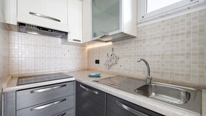 A modern kitchen with a stainless steel sink, a built-in oven, and a window above the sink. - Holiday Apartment "Numero 7" with Sea View, 2 Balconies & Wi-Fi (Pietra Ligure)
