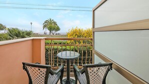 A balcony with a round table and chairs, a view of the sea, and a palm tree. - Studio Apartment "Monolocale 12" with Sea View, Wi-Fi & Air Conditioning (Pietra Ligure)