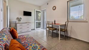 Une chambre à coucher avec un lit, un bureau, une chaise, une télévision et une fenêtre.