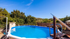 An above-ground swimming pool with a wooden deck and metal handrails. - Guest House 'Apartment Tina Capdepera' with Private Pool, Wi-Fi and Air Conditioning (Capdepera)