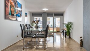 A dining area with a glass table, four chairs, and a vase with flowers. - Apartment 'Cala De Mijas' with Shared Pool, Wi-Fi and Air Conditioning (La Cala de Mijas)
