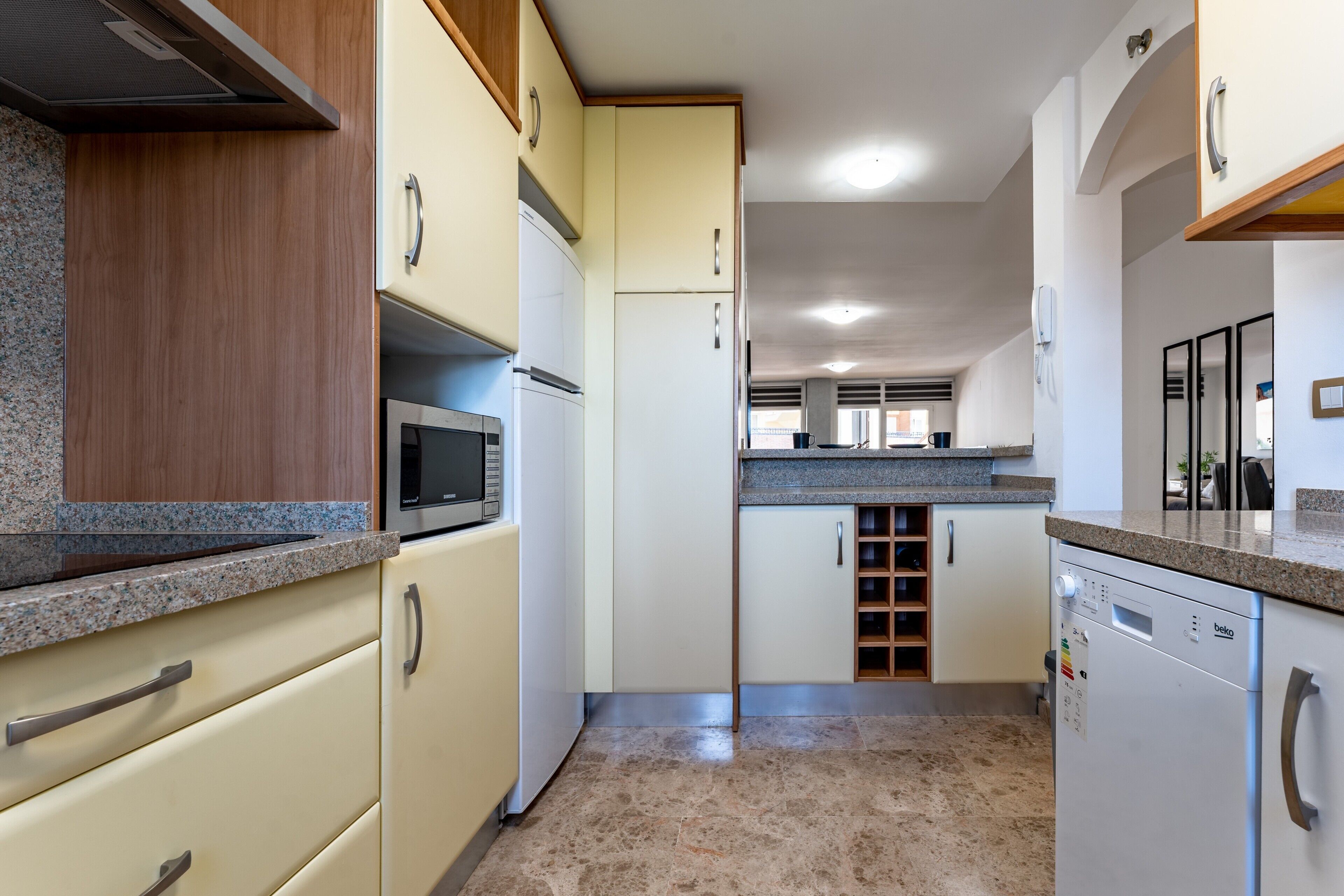 A kitchen with a microwave, refrigerator, and dishwasher.
