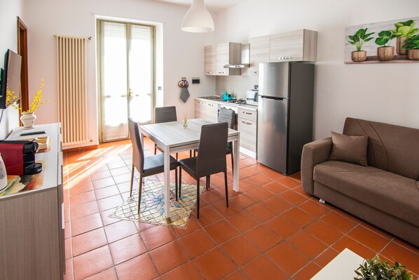 Un espace de vie compact comprenant un coin repas, une kitchenette et un canapé.
