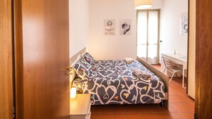 A bedroom with a bed, a desk, a chair, and a door. - Apartment 'L'Angolo di Torino' with Balcony and Wi-Fi (Torino)