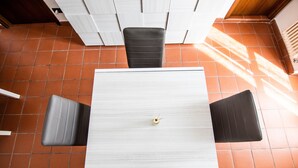 A square table with a central round object, surrounded by four black chairs. - Apartment 'L'Angolo di Torino' with Balcony and Wi-Fi (Torino)