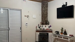 Un espace de vie compact doté d’une cheminée, d’un téléviseur fixé au mur et d’un placard avec porte coulissante.