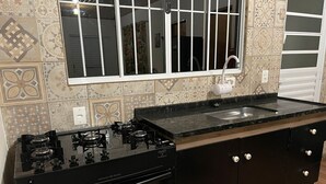 Une cuisine équipée d’une cuisinière à gaz, d’un four et d’un évier.