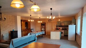 A spacious kitchen with wooden cabinets, a dining table, and a built-in washing machine.