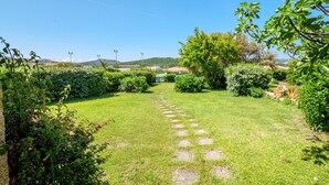 Un sendero en un jardín que lleva a un edificio con vista despejada del paisaje circundante.