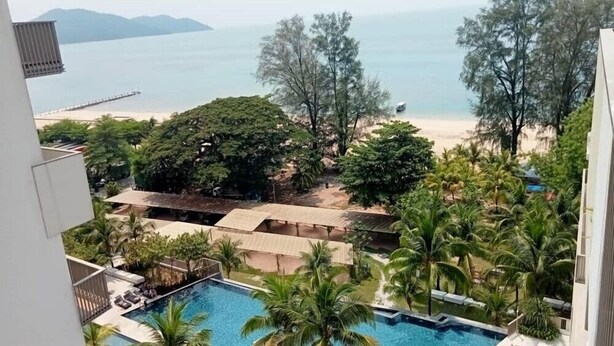 A pool area with a view of the beach and ocean. - By The Sea (George Town)