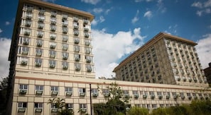 Hotel de vários andares com arquitetura clássica, apresentando várias varandas e fachada simétrica.