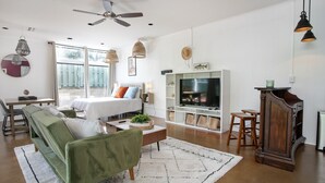 A modern living room with a green sofa, a coffee table, a TV, and a fireplace.