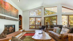 A spacious living room with a fireplace, large windows, and a cozy seating area. - Large East Vail Home - Hot Tub & Steps to Bus Stop (Vail)